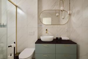 a bathroom with a sink and a mirror at Apartament Teatralny - Komfort w Sercu Miasta Klimatyzacja in Opole