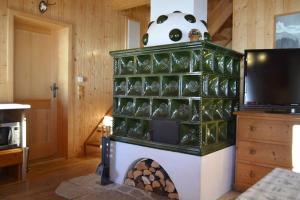 a fireplace with green and white in a room at Urgemütliche Lennkhütte in Rauris