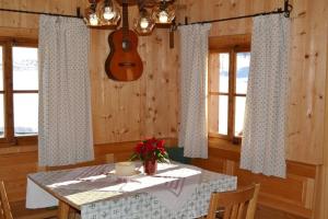 a dining room with a table and a guitar on the wall at Urgemütliche Lennkhütte in Rauris