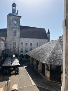 a large stone building with a clock tower at Le Haut des Halles in Martel