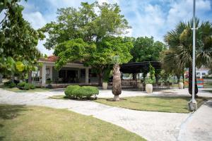 a house with a palm tree in front of it at Luxurious Punta Cana House 3 Bedrooms, Shared Pool, BBQ in Punta Cana