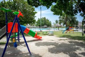 a playground with a slide in a park at Luxurious Punta Cana House 3 Bedrooms, Shared Pool, BBQ in Punta Cana