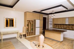 a kitchen with white walls and wooden cabinets and a table at Poolside View Guest House in Kigali