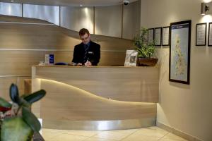 a man sitting at a counter in an office at Sure Hotel by Best Western Aberdeen in Aberdeen