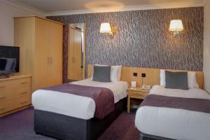 a hotel room with two beds and a television at Sure Hotel by Best Western Aberdeen in Aberdeen