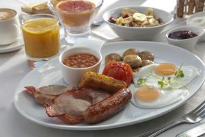 a plate of breakfast food with eggs sausage and beans at Best Western Moores Central Hotel in St. Peter Port