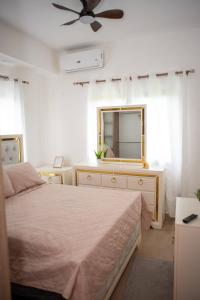 a bedroom with a bed and a dresser with a mirror at Luxurious Punta Cana House 3 Bedrooms, Shared Pool, BBQ in Punta Cana +109 photos