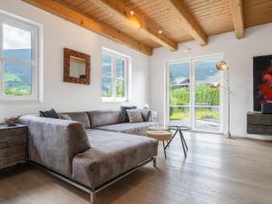a living room with a couch and windows at Chalet Sendlhofer in Bad Hofgastein