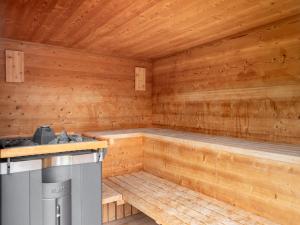 an empty sauna with a stove and wooden walls at Chalet Sendlhofer in Bad Hofgastein