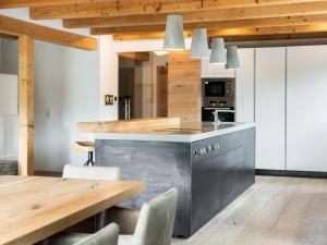 a kitchen with a wooden table and a wooden ceiling at Chalet Sendlhofer in Bad Hofgastein +37 photos