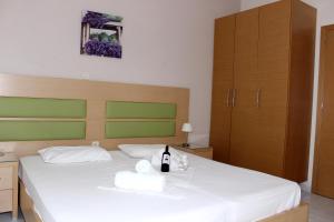 a bedroom with a bed with a bottle of wine on it at Angela Apartments in Kavos
