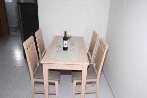 una mesa de madera con una botella de vino. en Angela Apartments en Kavos