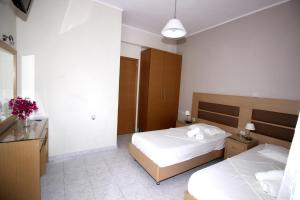 a hotel room with two beds and a bathroom at Angela Apartments in Kavos