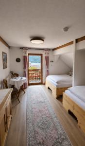 a room with two beds and a table and a window at Café Pension Leopoldine in Hallstatt