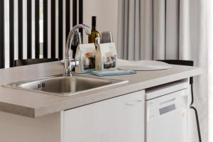 a kitchen counter with a sink with a bottle of wine at NEP APT Gennadi in Gennadi +75 photos