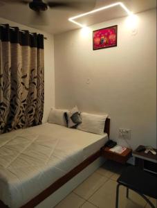 a bedroom with a large bed with a window at Hotel Kalyan in Rajkot +4 photos