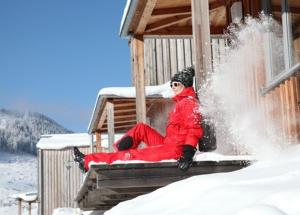 a person sitting on a porch in the snow at Hüttendorf Präbichl 1 in Vordernberg