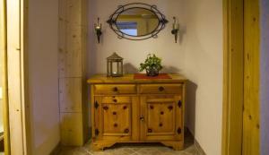 a small wooden cabinet with a mirror on a wall at Ferienhaus Staller Brendl in Sankt Georgen in Obdachegg
