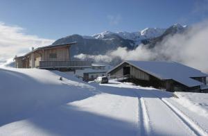 a ski lodge in the snow with mountains in the background at Schauinstal Appartement 2 in Lutago