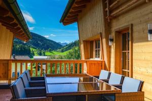 a deck with chairs and a glass table on a house at Gams Lodge 2 in Weng