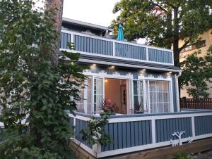 a house with a blue fence and a balcony at Apartment Sonata in Jūrmala