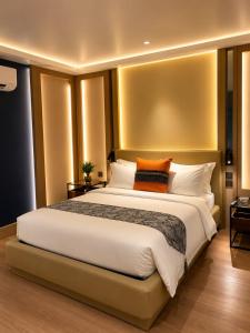 a bedroom with a large white bed with orange pillows at Madigun Hotel and Events in San Francisco +44 photos