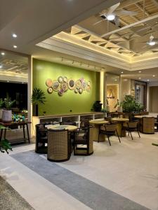 a restaurant with tables and chairs and a green wall at Madigun Hotel and Events in San Francisco