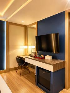 a room with a desk with a television on a blue wall at Madigun Hotel and Events in San Francisco