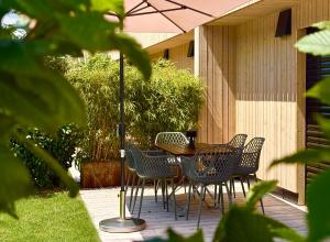 a table and chairs with an umbrella on a patio at Hinterland&See in Tettnang