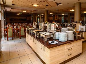 a restaurant with a buffet line with plates and dishes at Termálhotel Martfű in Martfů