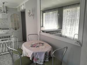 a dining room with a table and chairs and a mirror at Apartment Sonata in Jūrmala
