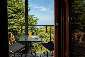 a table and chairs on a balcony with a view at Adilon in Tsagarada
