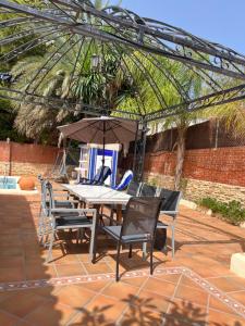 a patio with a table and chairs and an umbrella at VILLA San Juan PLAYA Alicante in El Campello