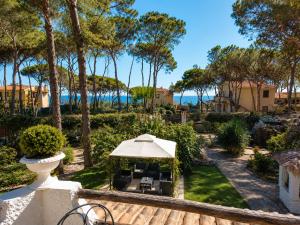 a garden with an umbrella and chairs and trees at La Villetta Adults Only con giardino a Pula in Pula