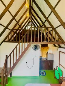 an attic room with a wooden staircase and a basketball hoop at Rainforest cabin in Deniyaya