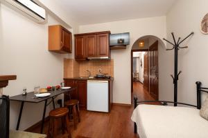 a kitchen with wooden cabinets and a table in a room at Adilon in Tsagarada +55 photos