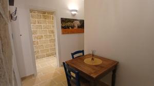 a dining room with a wooden table and chairs at Casale Mute Terre in Tuglie