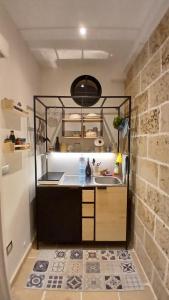 a kitchen with a sink and a brick wall at Casale Mute Terre in Tuglie