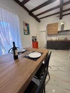 a dining room table with a bottle of wine on it at Domus Tarquinia in Tarquinia