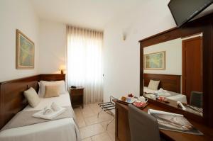 a hotel room with two beds and a mirror at Hotel Nuovo Metrò in Milan
