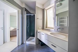 a bathroom with a sink and a shower and a mirror at IseoLakeRental - Collina Divina in Solto Collina +10 photos