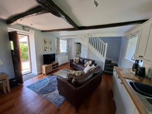a living room with a couch and a tv at The Old Stone Barn in Warrington