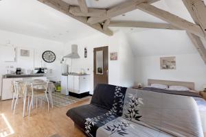 a living room with a couch and a kitchen at Studio 7 3 Min Du Futuroscope in Chasseneuil-du-Poitou
