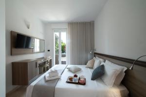 a hotel room with a bed with a tray of food on it at Hotel Nuovo Metrò in Milan +10 photos