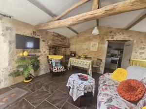 a living room with a bed and a table at Gite du Passignac in Saint-Maigrin
