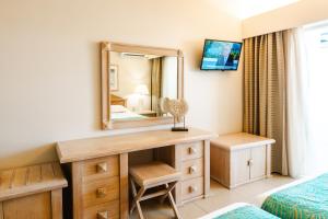 a bedroom with a vanity and a mirror at Halotels Porto Myrina in Myrina
