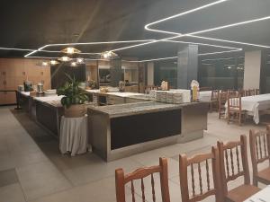 a restaurant with a large kitchen with tables and chairs at Hotel Ría Mar 3 estrellas Superior in Villalonga