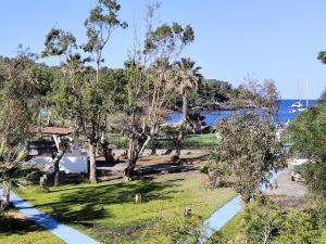 a park with trees and a body of water at Villetta Darsena con piscina gratuita dal 18 Luglio al 30 Agosto in Vulcano