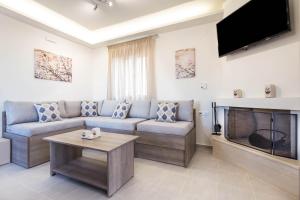 a living room with a couch and a tv at Villa Thea in Triopetra