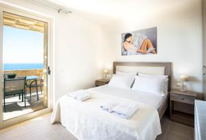 a bedroom with a bed and a view of the ocean at Villa Thea in Triopetra +29 photos